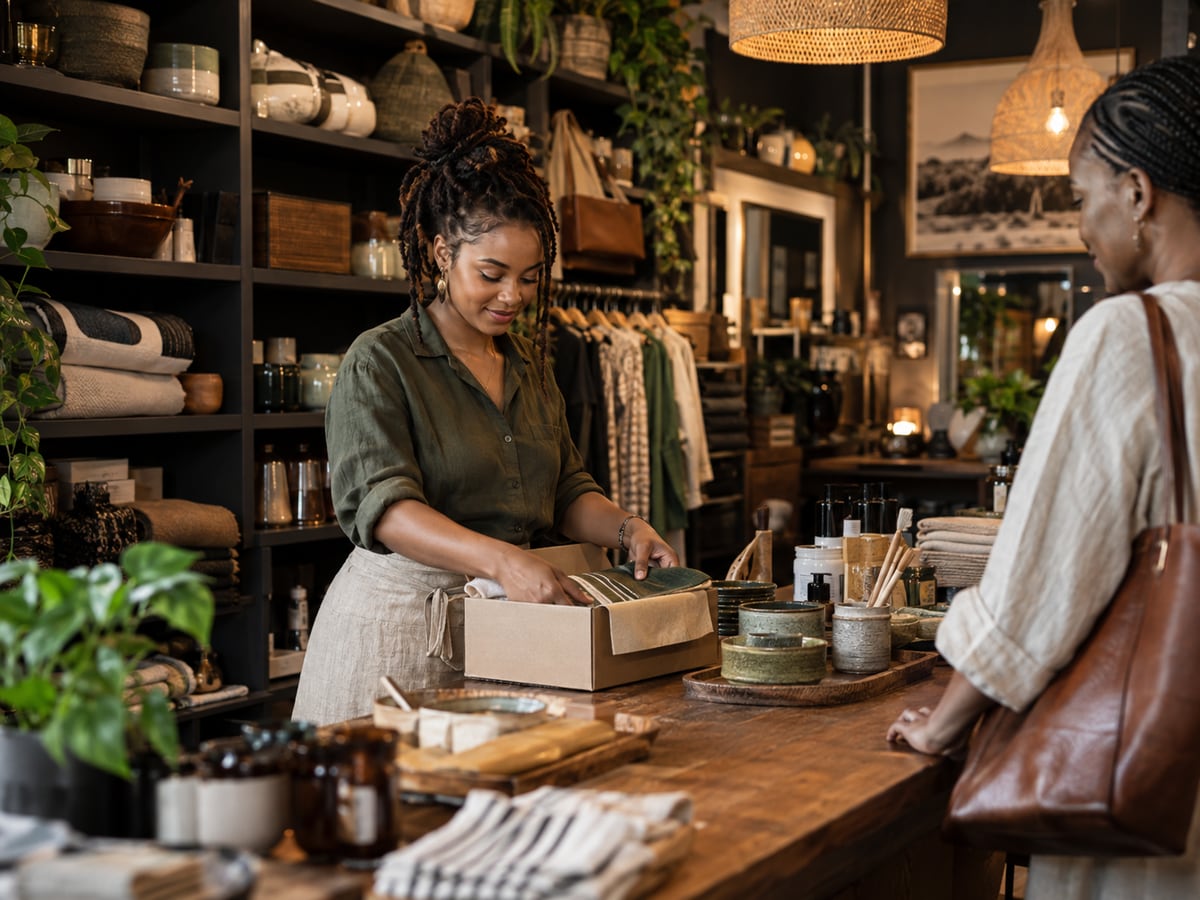 A South African small-business owner packing an order for a customer at her counter